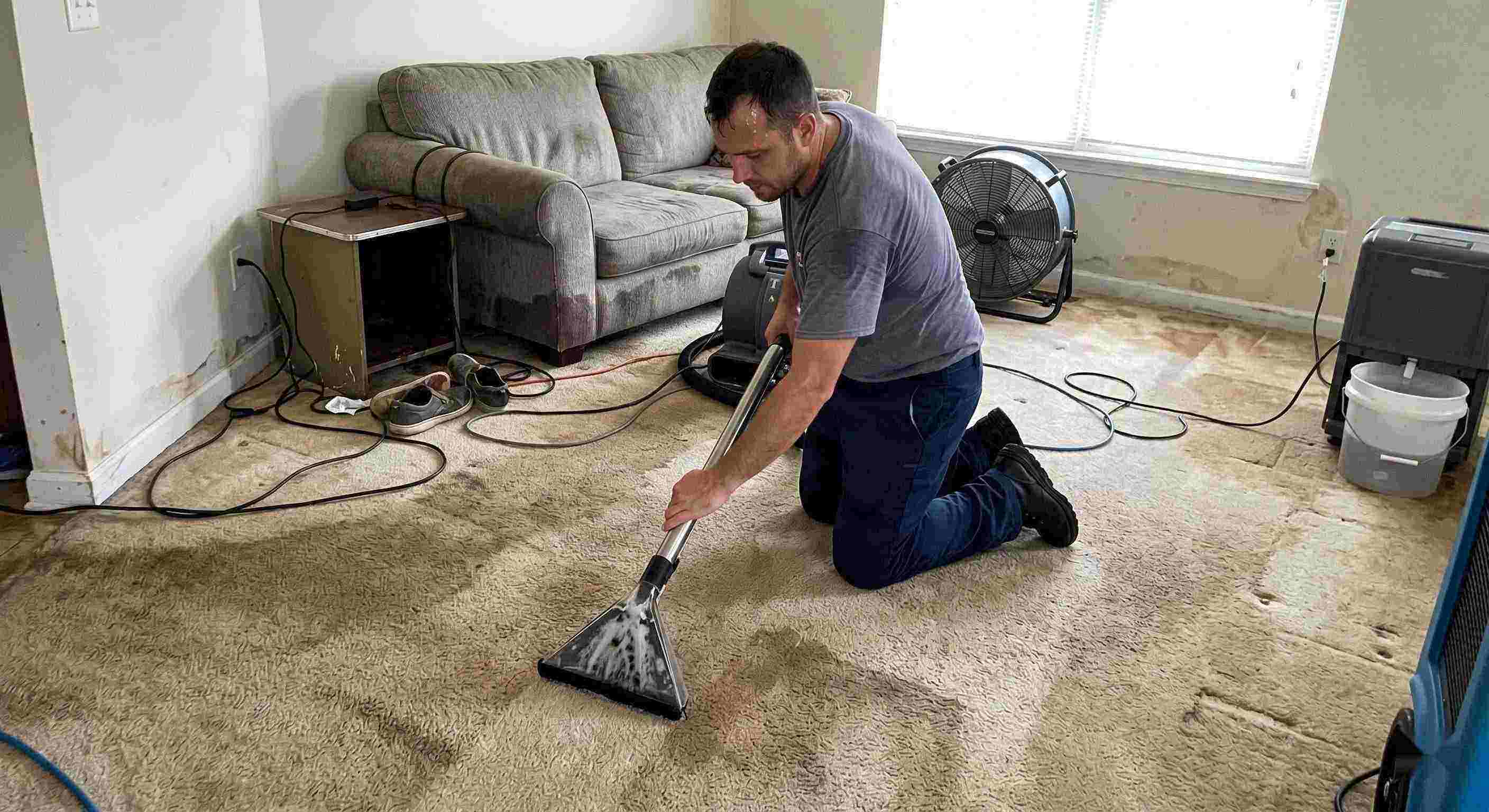 Trusted technician performing carpet water extraction in a residential home using professional equipment after water damage in Downey