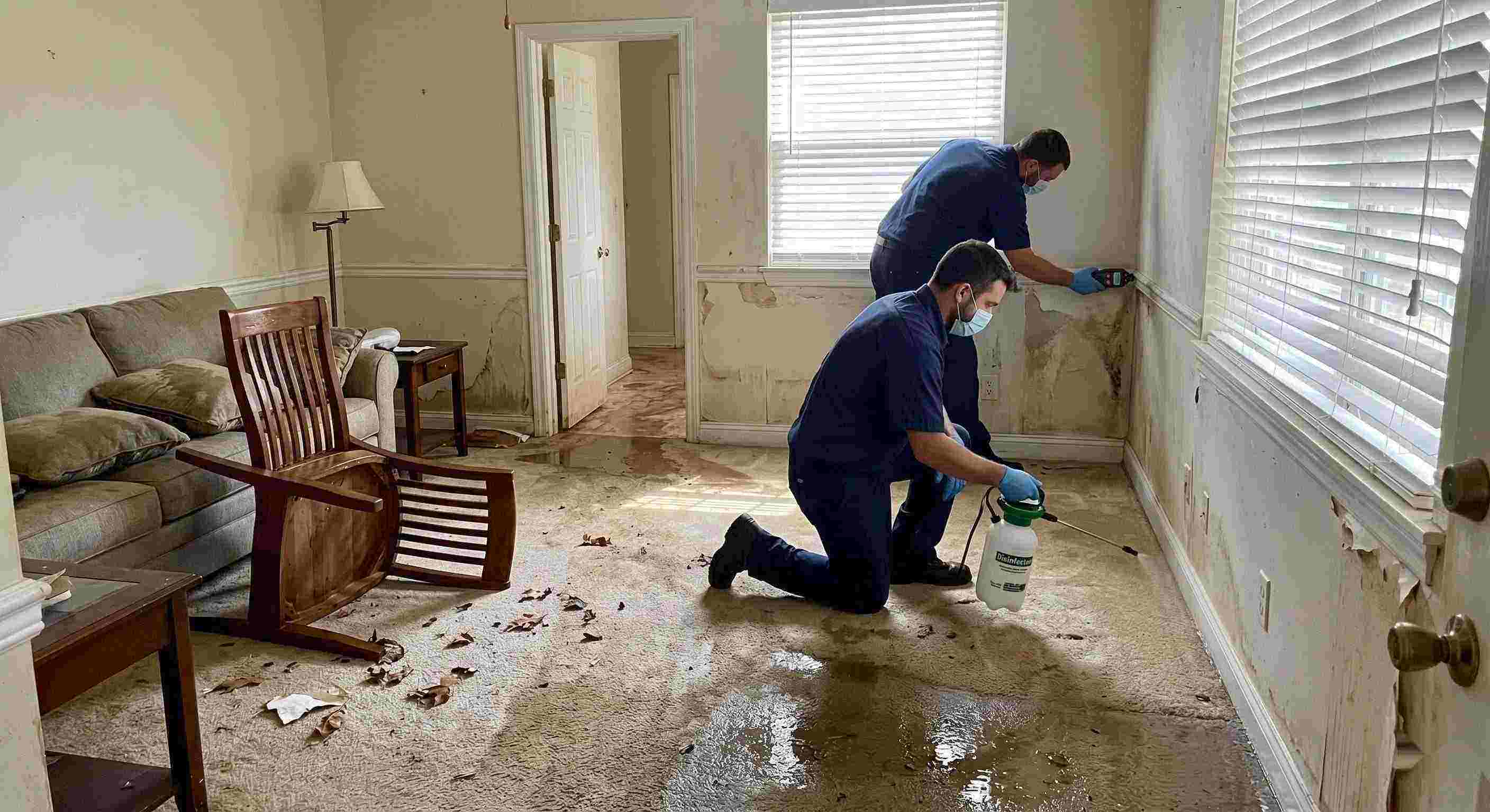 Technicians performing flood disinfection after water damage inside a home in Irvine, ensuring wet floors, damp walls, and household items are sanitized safely.