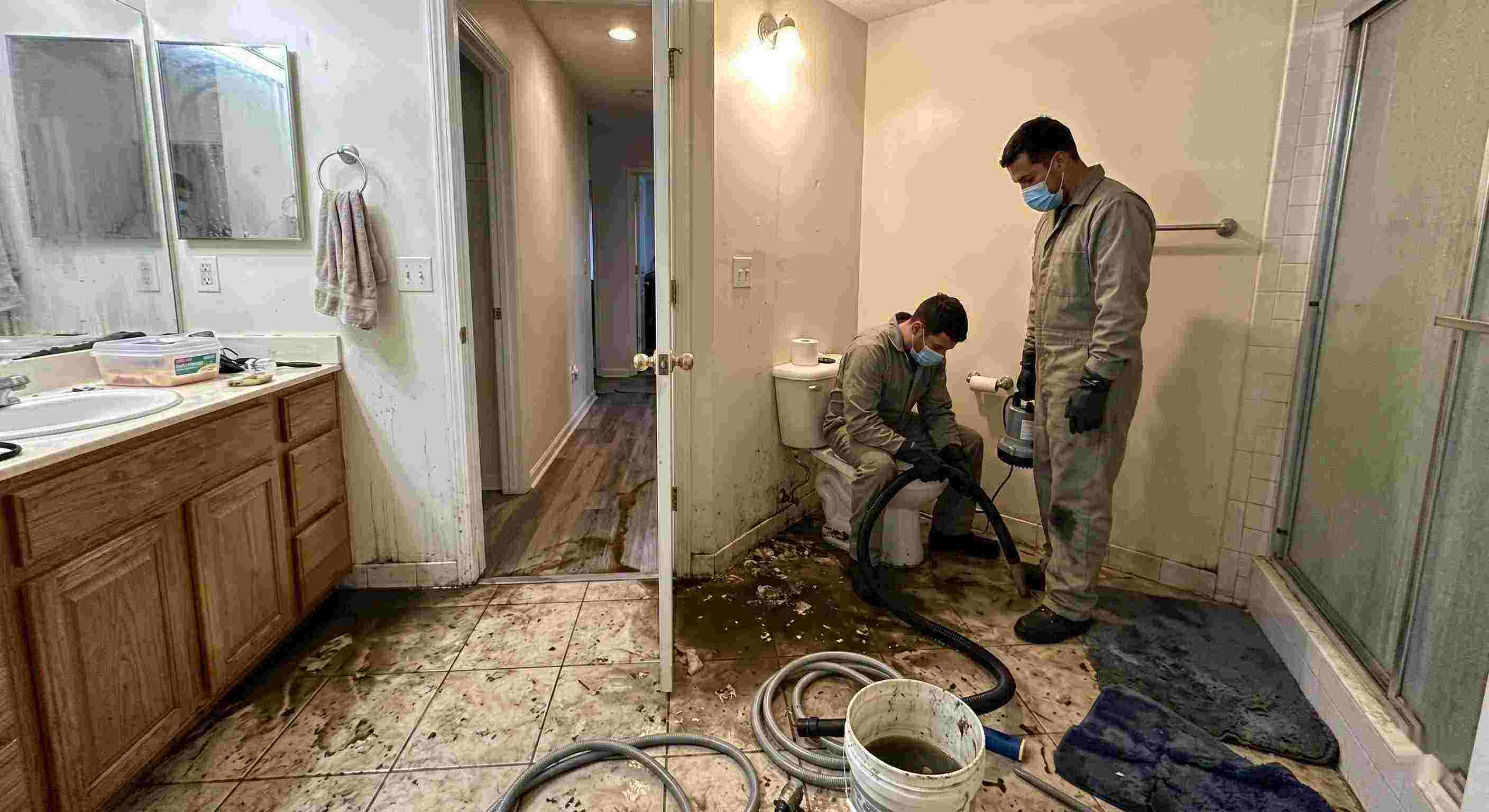 Fast septic tank backup cleanup in Orange bathroom with technicians removing contaminated water and sanitizing affected areas